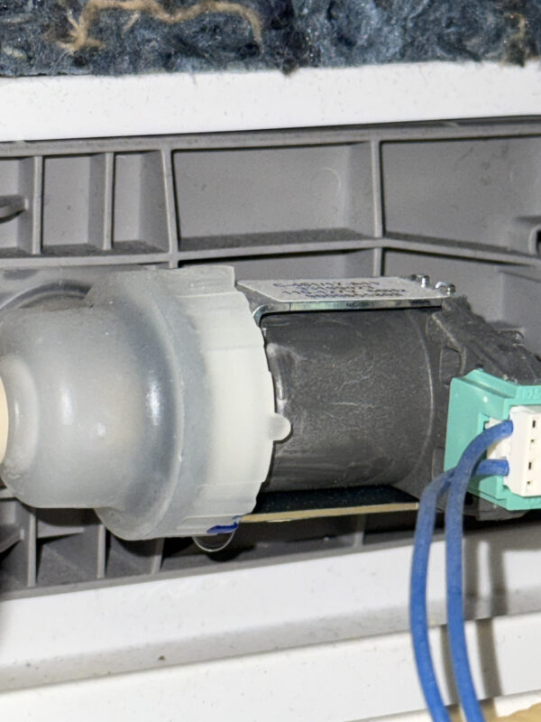 Common issue—leaking water valve.Slow drips fill the overflow tray, preventing major leaks. Look closely to see a hanging droplet.