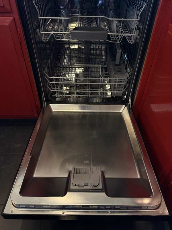 The dishwasher door is open. To access the control panel, at least the top screws need to be removed to detach the plastic panel, or for easier access, the metal panel can also be removed.