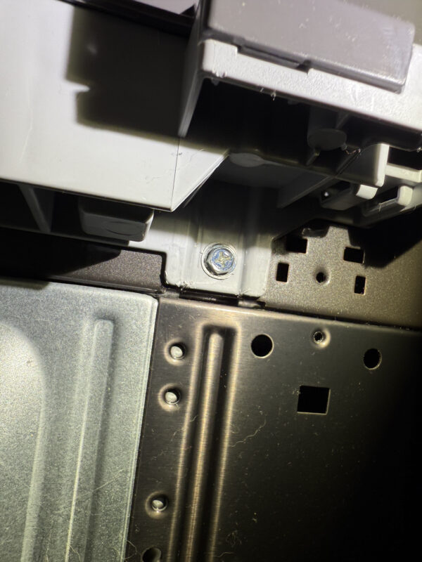 Two hidden screws in the back, left and right—must be removed.